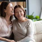 Happy,Senior,Mother,And,Grownup,Daughter,Sit,Relax,On,Couch