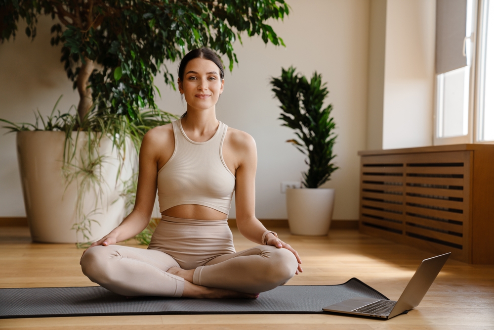 Young,White,Woman,Using,Laptop,During,Yoga,Practice,On,Mat