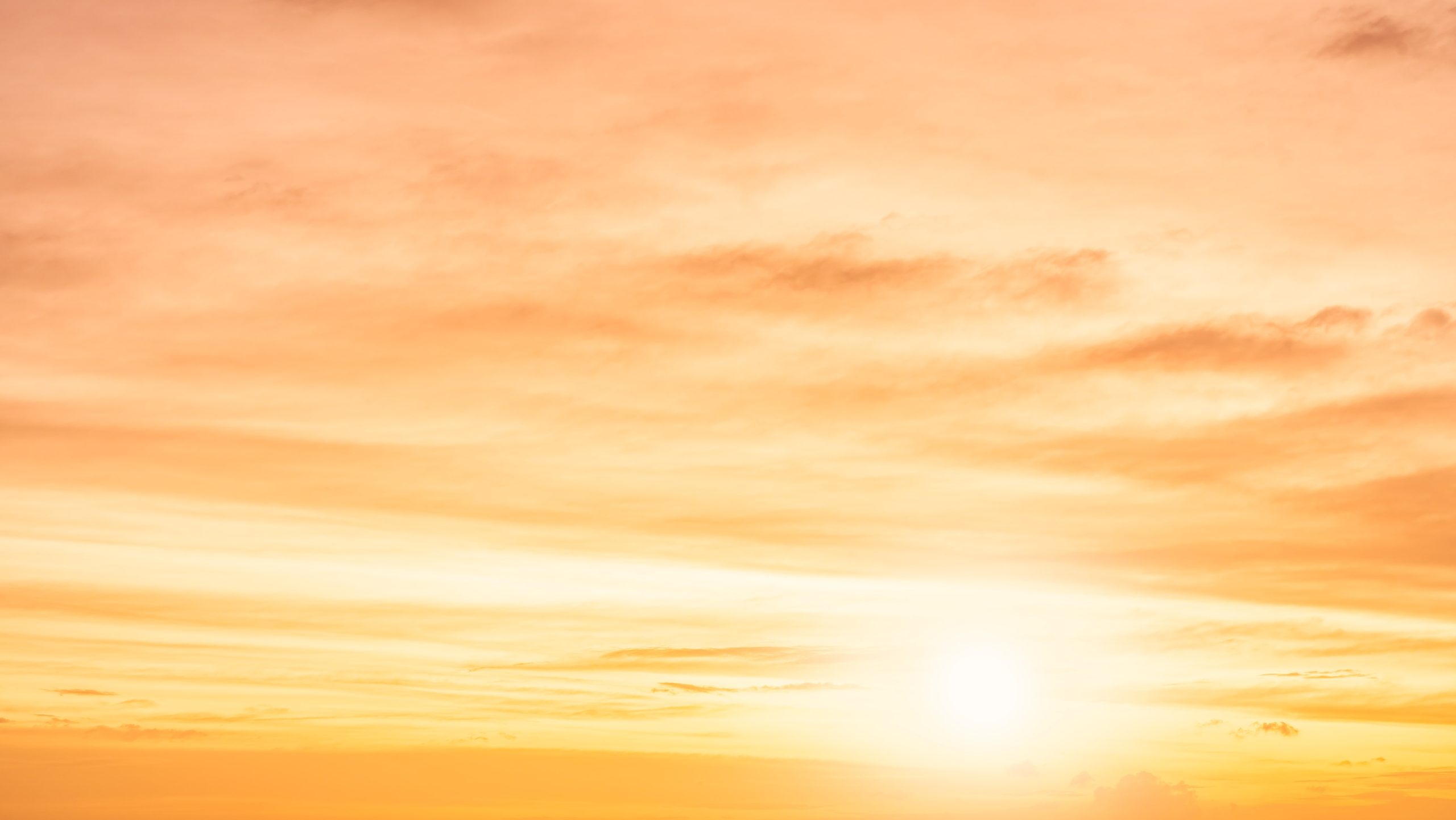 Golden sunrise sky with warm orange clouds, calming wellness and mindfulness scene.